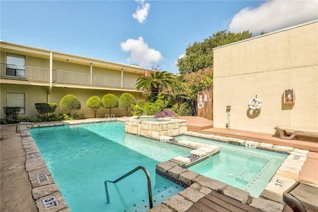 view of swimming pool featuring pool water feature, a hot tub, and a patio area