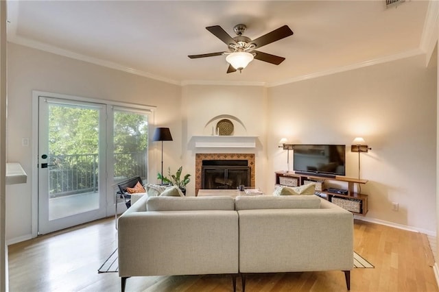 living room featuring ceiling fan, crown molding, and light hardwood / wood-style flooring