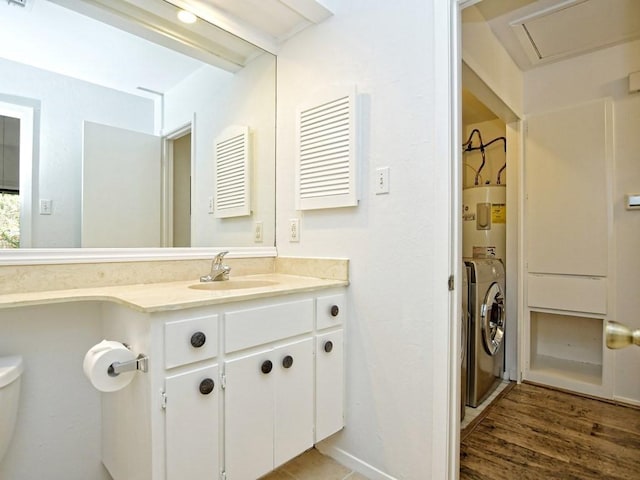 bathroom with vanity, washer and dryer, toilet, and water heater