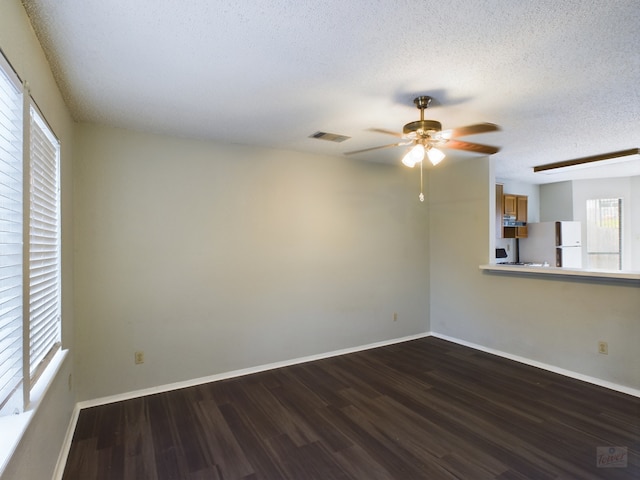 spare room featuring a textured ceiling, ceiling fan, and dark hardwood / wood-style floors