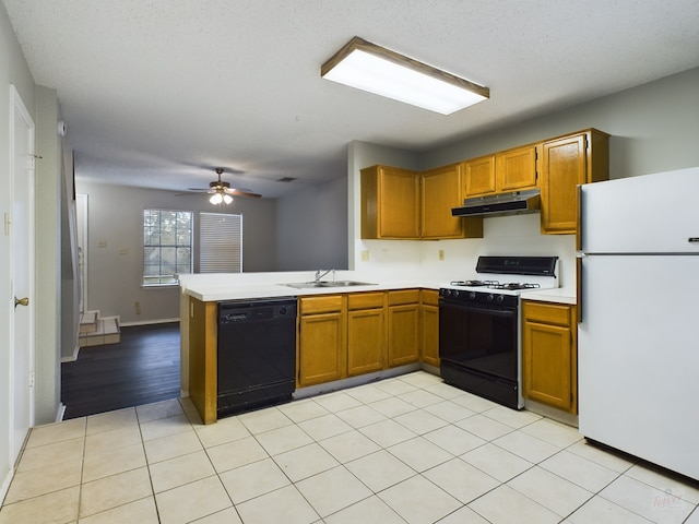 kitchen with kitchen peninsula, range with gas stovetop, white refrigerator, ceiling fan, and black dishwasher