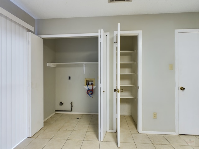 clothes washing area featuring gas dryer hookup, light tile patterned floors, hookup for a washing machine, and hookup for an electric dryer