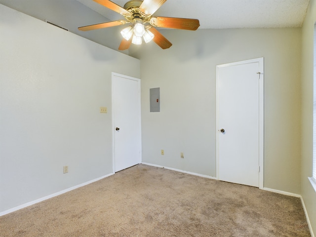 spare room featuring ceiling fan, light colored carpet, lofted ceiling, and electric panel