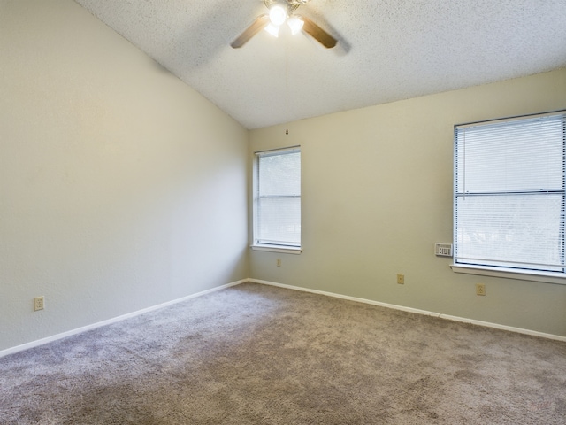 carpeted spare room with a textured ceiling, ceiling fan, and lofted ceiling