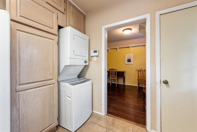 clothes washing area with stacked washer / drying machine and light hardwood / wood-style flooring