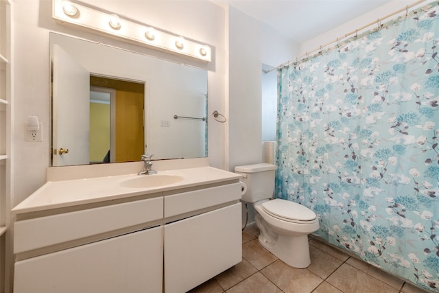 bathroom featuring tile floors, vanity, and toilet