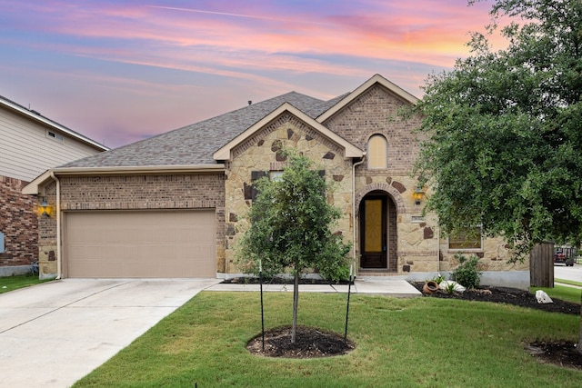 view of front of property featuring a garage and a yard