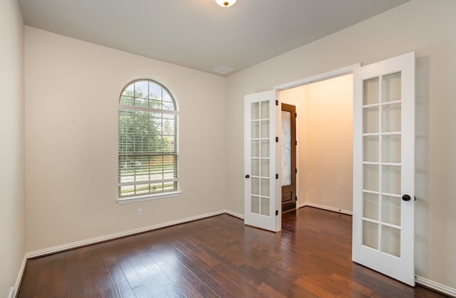 empty room with french doors and dark hardwood / wood-style flooring