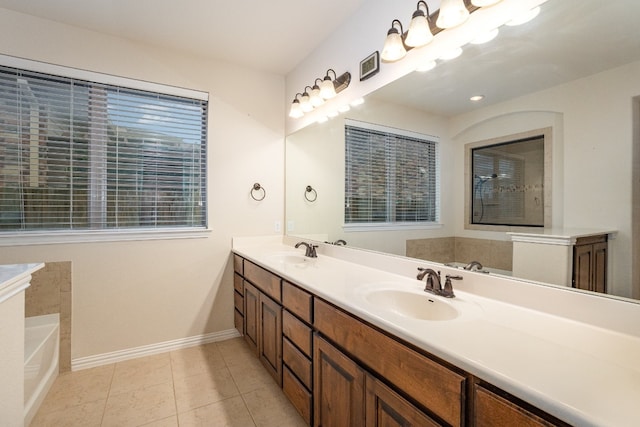 bathroom featuring a wealth of natural light, vanity, a bathtub, and tile patterned floors