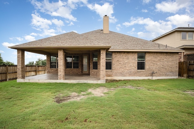 back of house featuring a patio and a yard