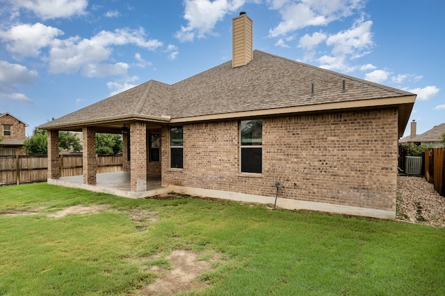 back of property featuring central AC unit, a lawn, and a patio area