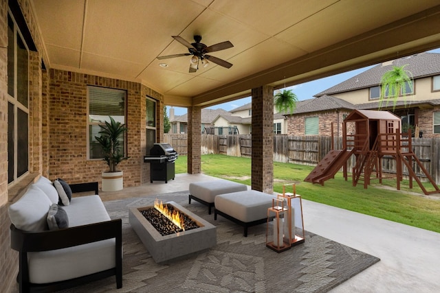 view of patio featuring a playground, ceiling fan, an outdoor living space with a fire pit, and a grill