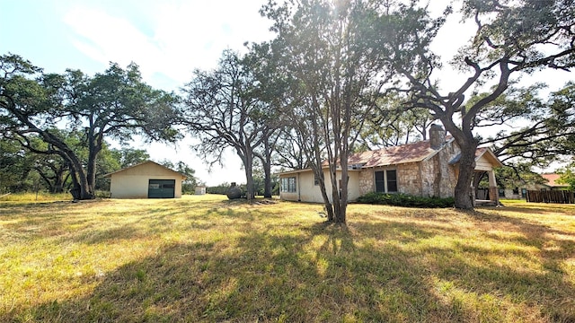 view of yard featuring an outdoor structure and a garage