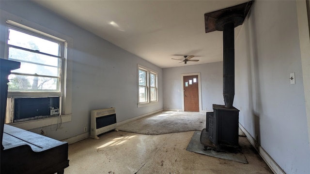 entrance foyer with ceiling fan and a wood stove