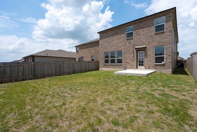 back of house featuring a patio area and a lawn