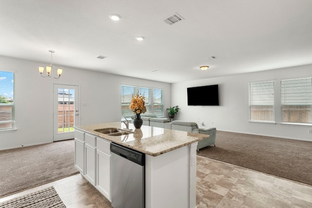 kitchen featuring stainless steel dishwasher, light colored carpet, decorative light fixtures, a center island with sink, and white cabinets