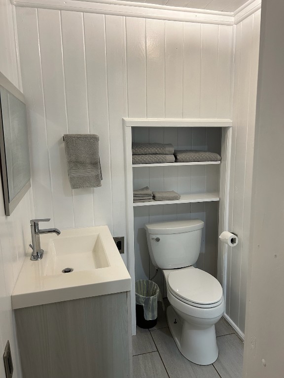 bathroom featuring tile patterned flooring, toilet, and vanity