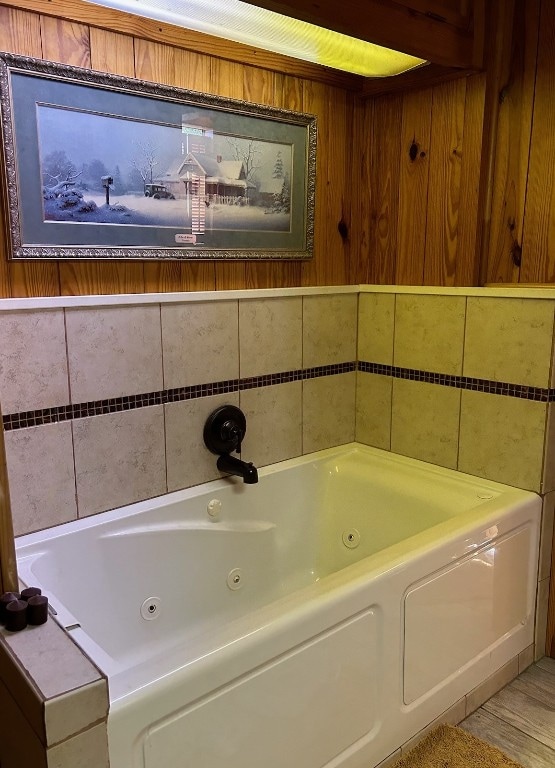 bathroom with wooden walls and a bathtub