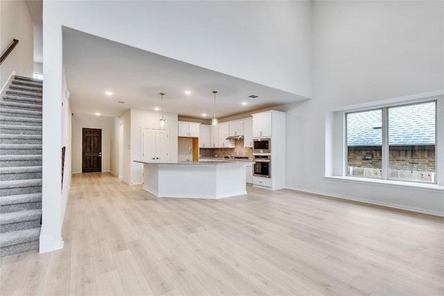 unfurnished living room featuring light wood-type flooring and sink