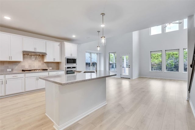 kitchen featuring stainless steel appliances, white cabinetry, a kitchen island with sink, and sink