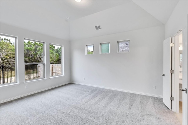 spare room featuring carpet and vaulted ceiling