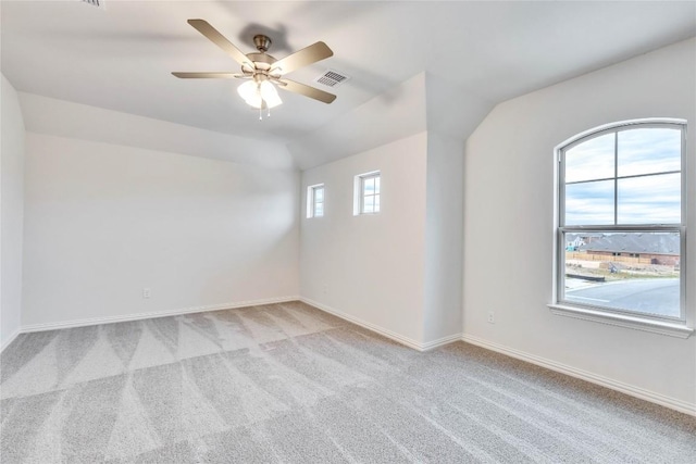 empty room featuring light colored carpet, vaulted ceiling, and ceiling fan