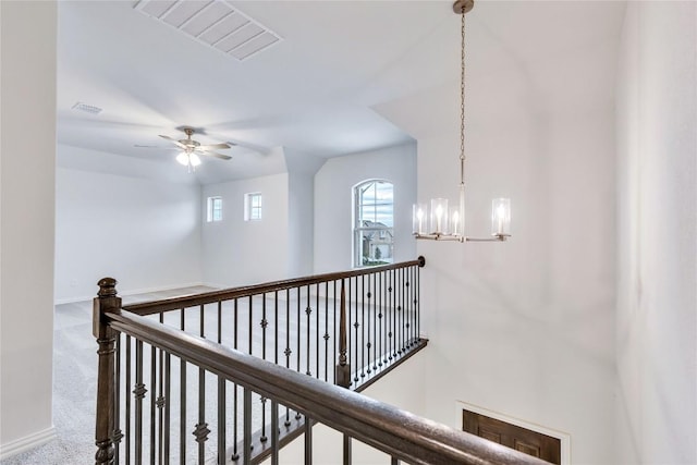 hall featuring carpet flooring and a notable chandelier