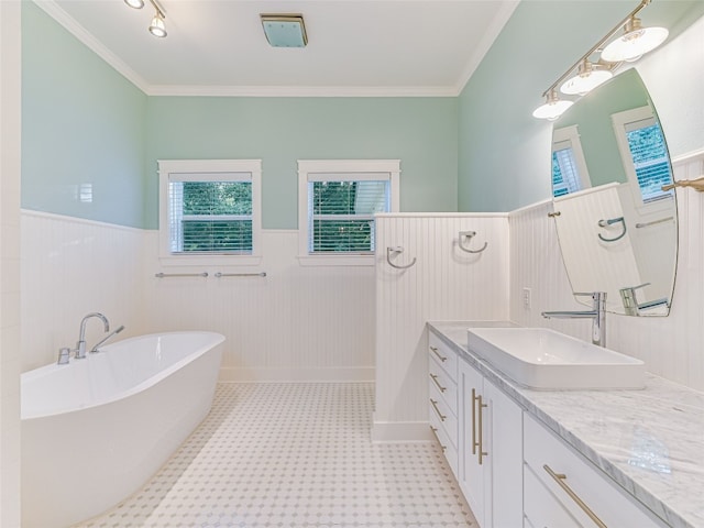 bathroom with a freestanding tub, ornamental molding, wainscoting, and vanity