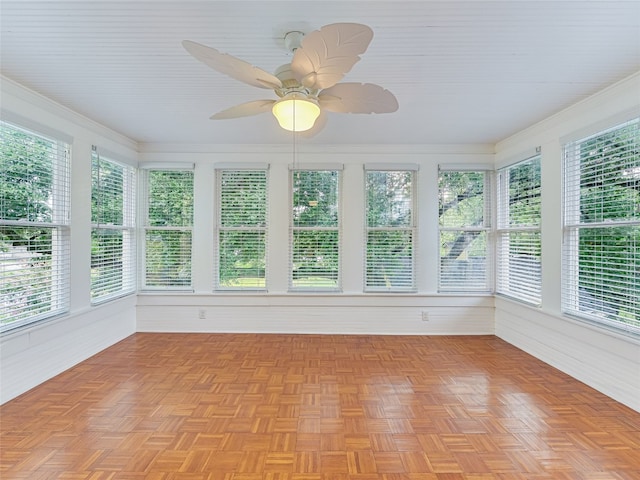unfurnished sunroom with ornamental molding and wood walls