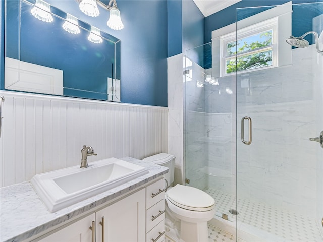 bathroom featuring ornamental molding, a shower with shower door, toilet, and vanity