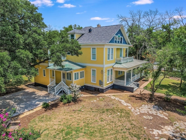 rear view of property with a porch and a lawn