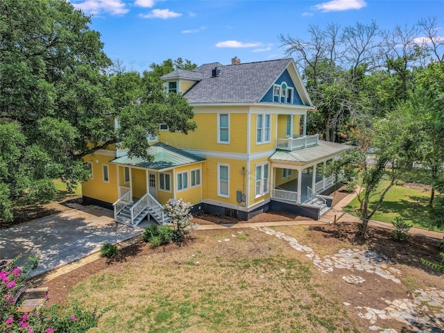 1302 Hill St, Bastrop, TX 78602 - rear view of property featuring a porch, a chimney, metal roof, a standing seam roof, and a balcony