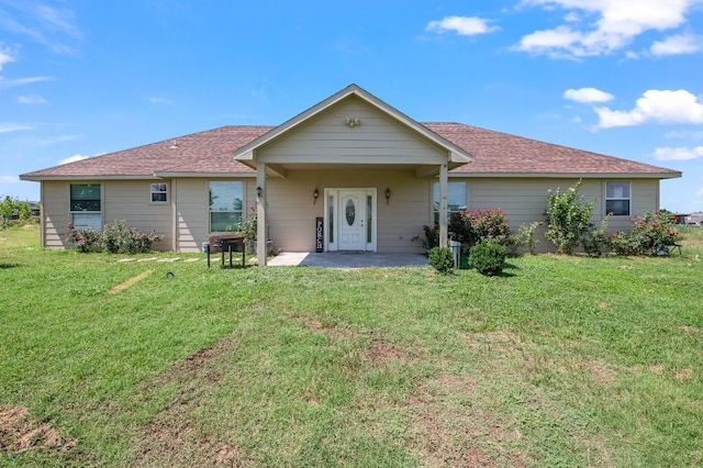 back of property featuring a yard