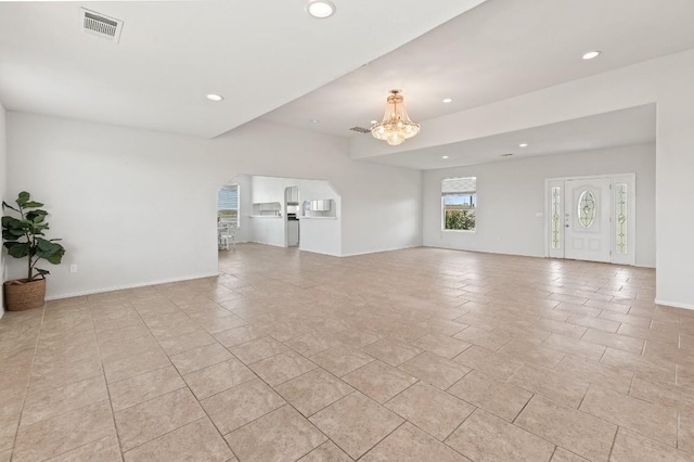 unfurnished living room with a notable chandelier