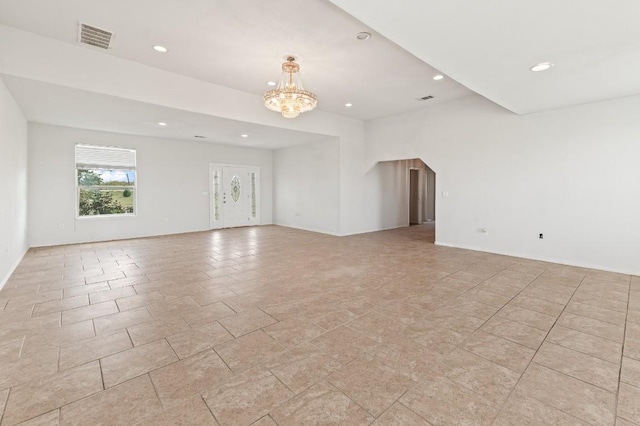 unfurnished room featuring a notable chandelier