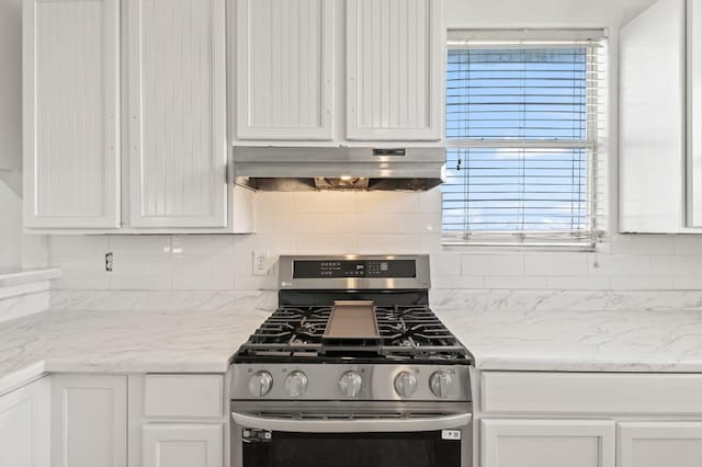 kitchen with backsplash, white cabinetry, light stone counters, and stainless steel gas range