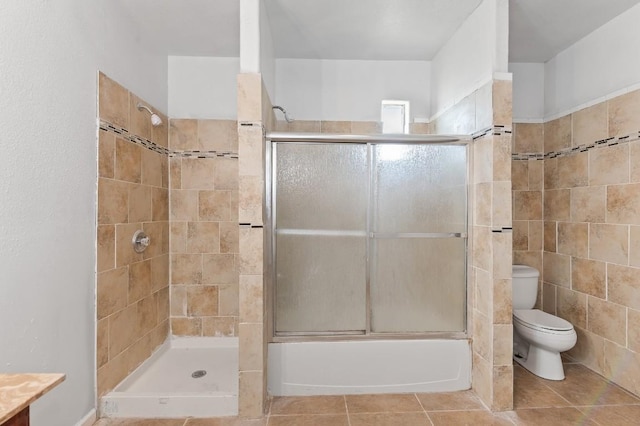 bathroom featuring combined bath / shower with glass door and toilet