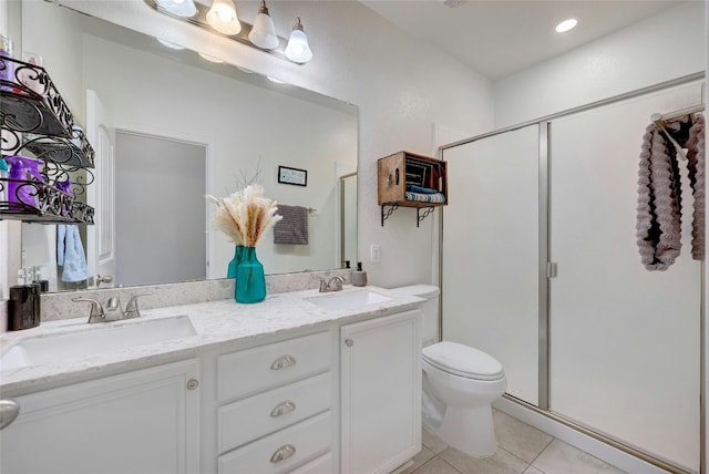 bathroom with tile patterned flooring, vanity, a shower with shower door, and toilet