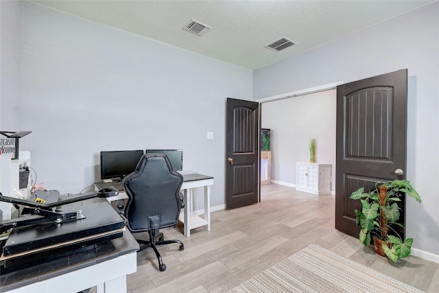 office space with light hardwood / wood-style flooring and a textured ceiling