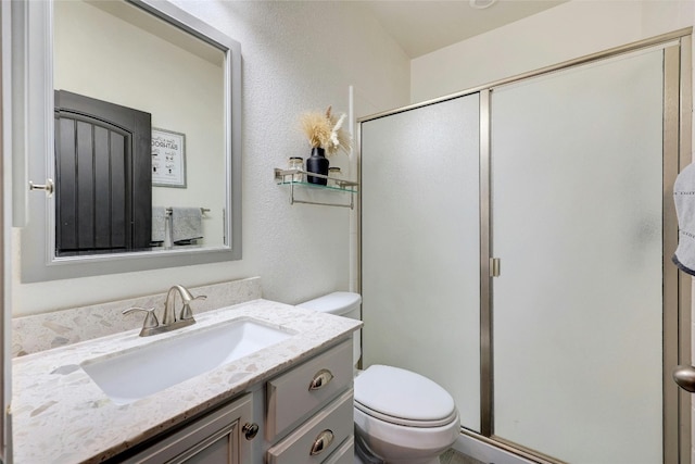 bathroom with vanity, an enclosed shower, and toilet