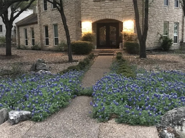 entrance to property featuring stone siding and french doors