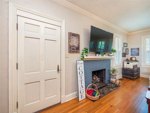 living room with hardwood / wood-style floors, ornamental molding, and a brick fireplace