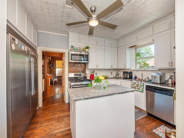 kitchen featuring appliances with stainless steel finishes, ceiling fan, a center island, dark hardwood / wood-style floors, and white cabinetry