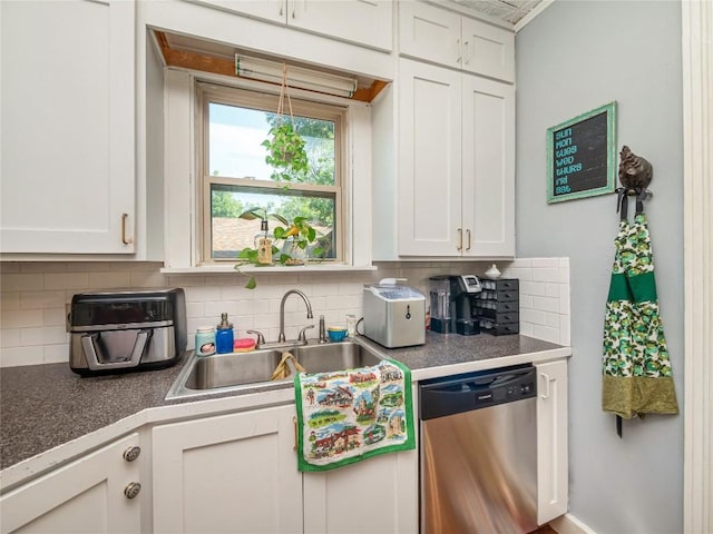 kitchen featuring stainless steel dishwasher, white cabinetry, sink, and tasteful backsplash