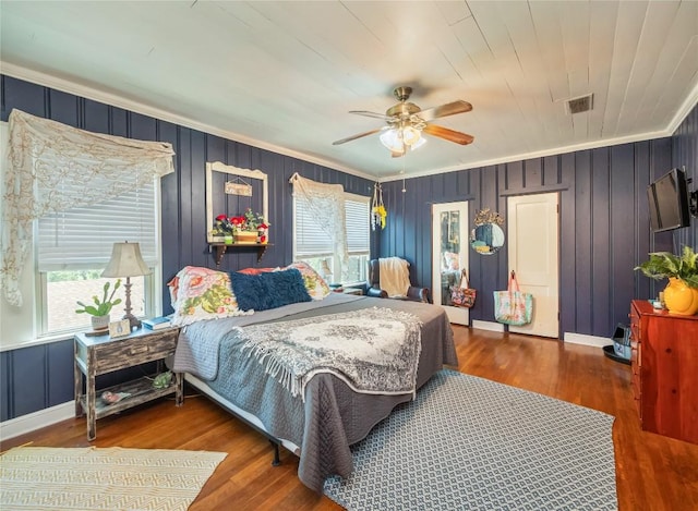 bedroom with hardwood / wood-style flooring, ceiling fan, crown molding, and multiple windows