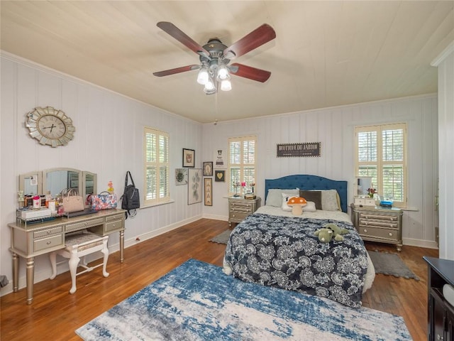 bedroom with multiple windows, wood-type flooring, ceiling fan, and ornamental molding