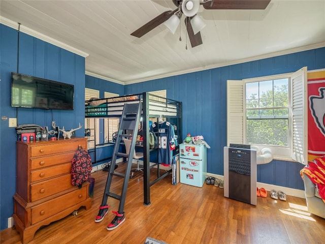 interior space featuring ceiling fan, wood-type flooring, and crown molding