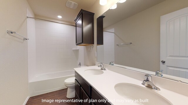 full bathroom with oversized vanity, dual sinks, toilet, hardwood / wood-style floors, and shower / bath combination