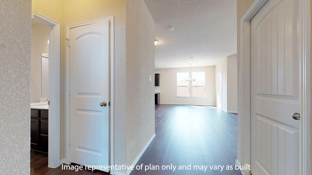 hallway featuring dark wood-type flooring and a textured ceiling