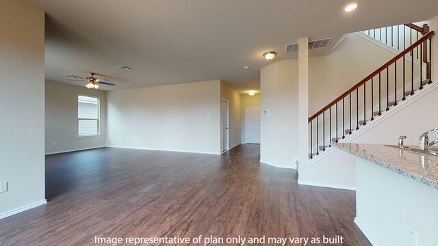 unfurnished living room featuring ceiling fan and dark hardwood / wood-style flooring